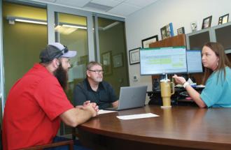 Apprentice Lineman III Cord Hughes, left, discusses the role of the safety department with Mark Dixon, former safety & loss control director, as well as the role of human resources with Heather Wigington, human resources manager. 